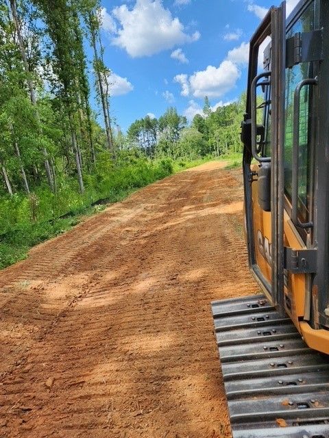 A bulldozer is driving down a dirt road