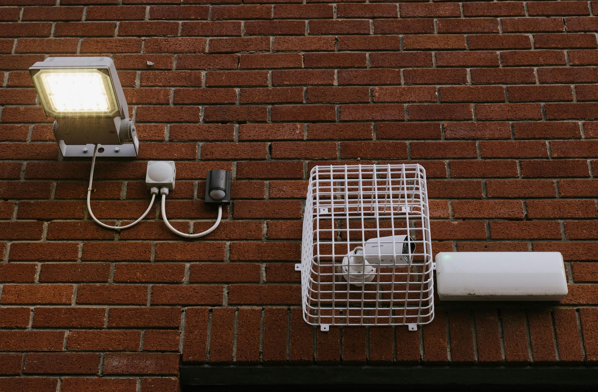 A brick wall with a light and a camera on it