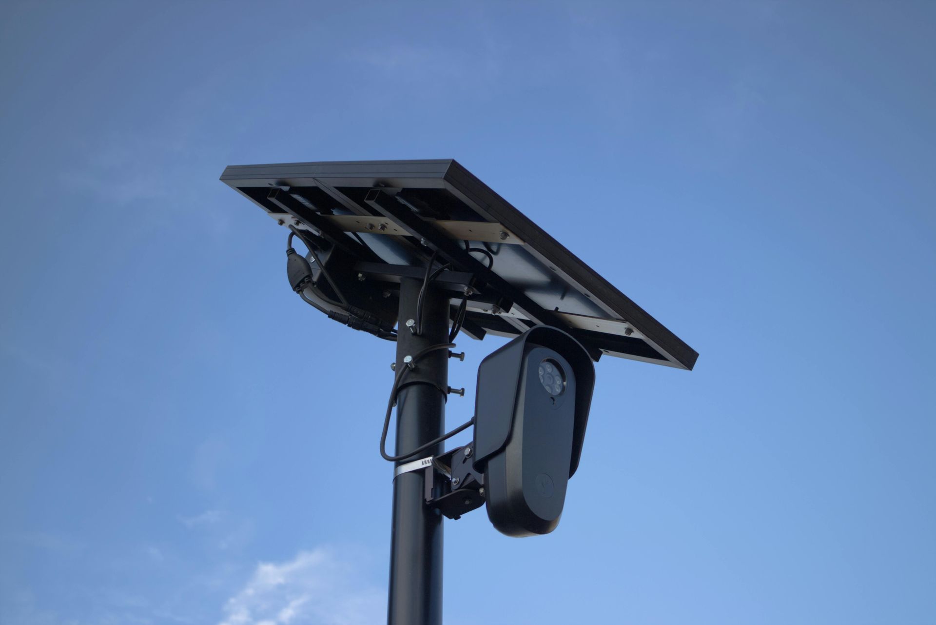 A solar panel is sitting on top of a pole.