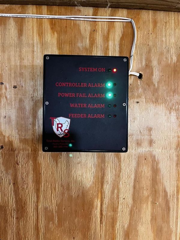 A black box is hanging on a wooden wall.