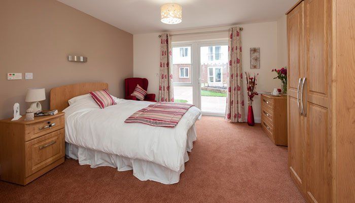 spacious bedroom with ensuite at Mayfields Care Home for dementia care patients in Long Stratton