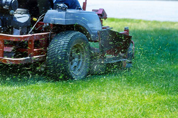 Red Lawn Mower Cutting Gras — Yorktown Heights, NY — Whispering Pine Landscape Supply Corp