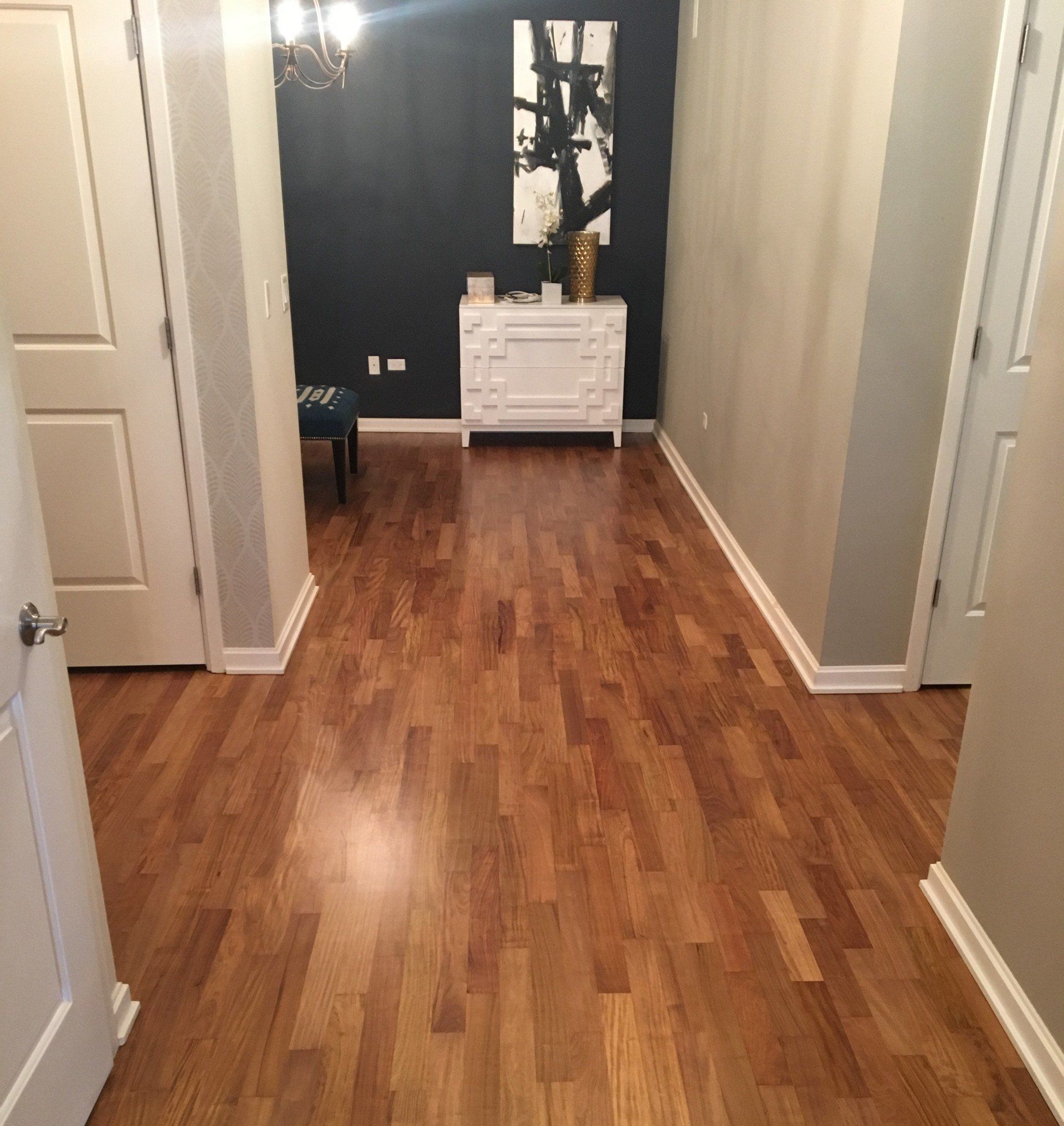 A hallway with hardwood floors and white doors