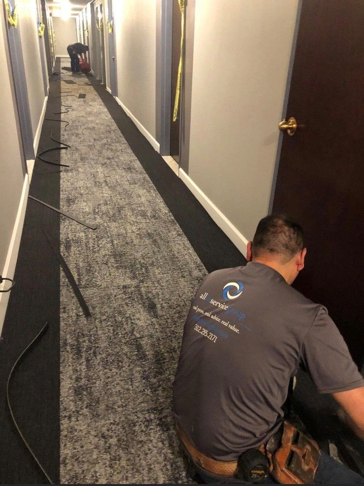 A hallway in an office with cubicles and a blue pillar