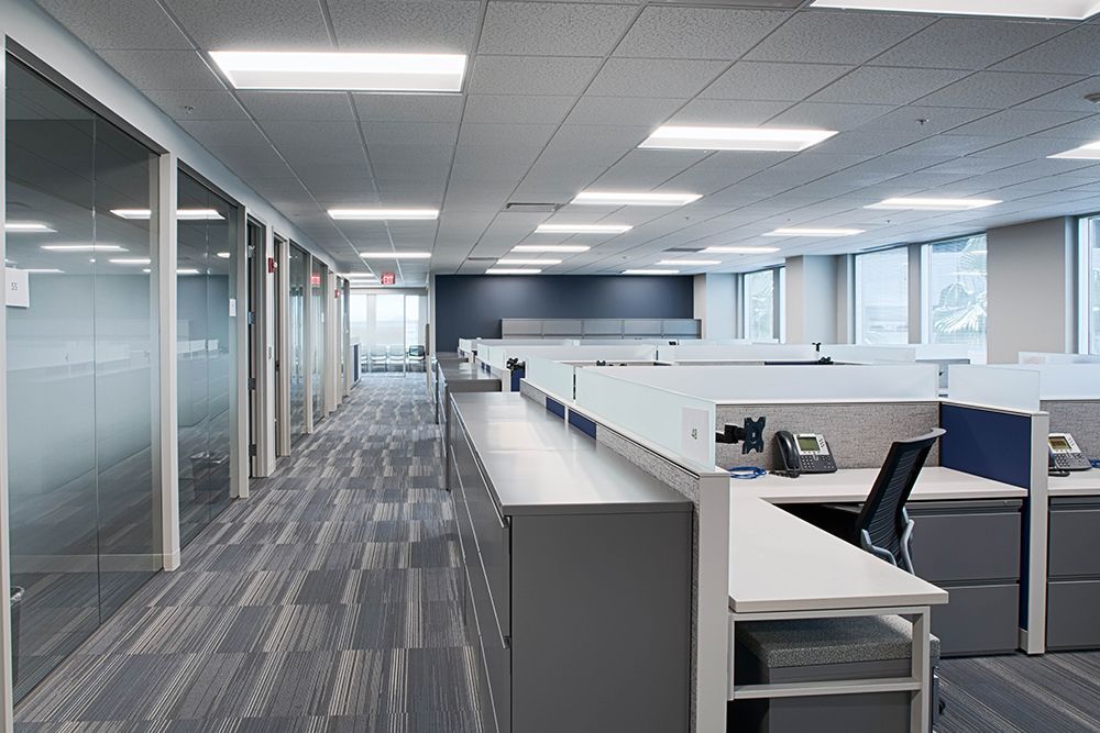 A large office with cubicles and a lot of windows