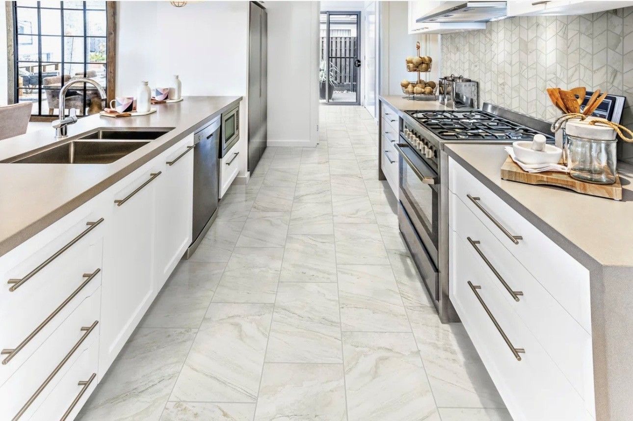 A kitchen with gray cabinets , white cabinets , stainless steel appliances and a large island.