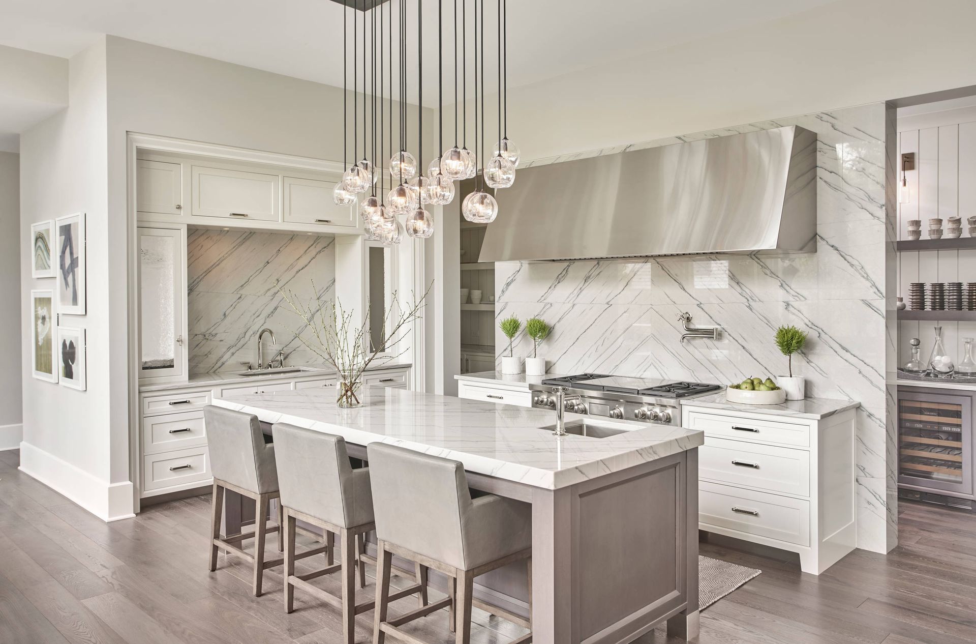 Bright modern white kitchen with island, pendant lights, and marble backsplash