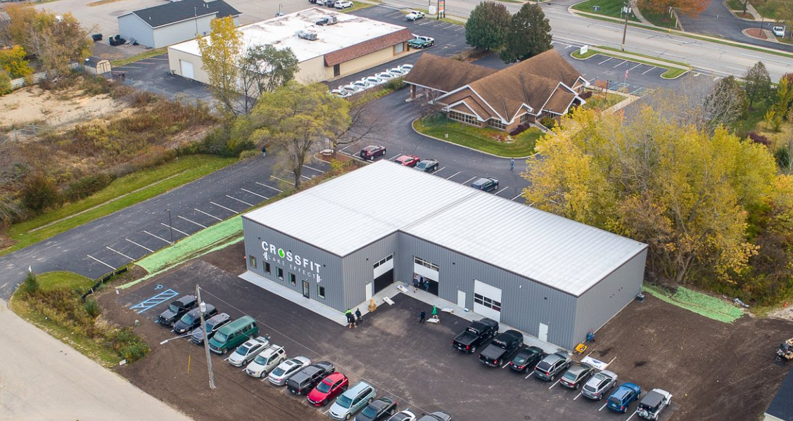 An aerial view of a building with a lot of cars parked in front of it.