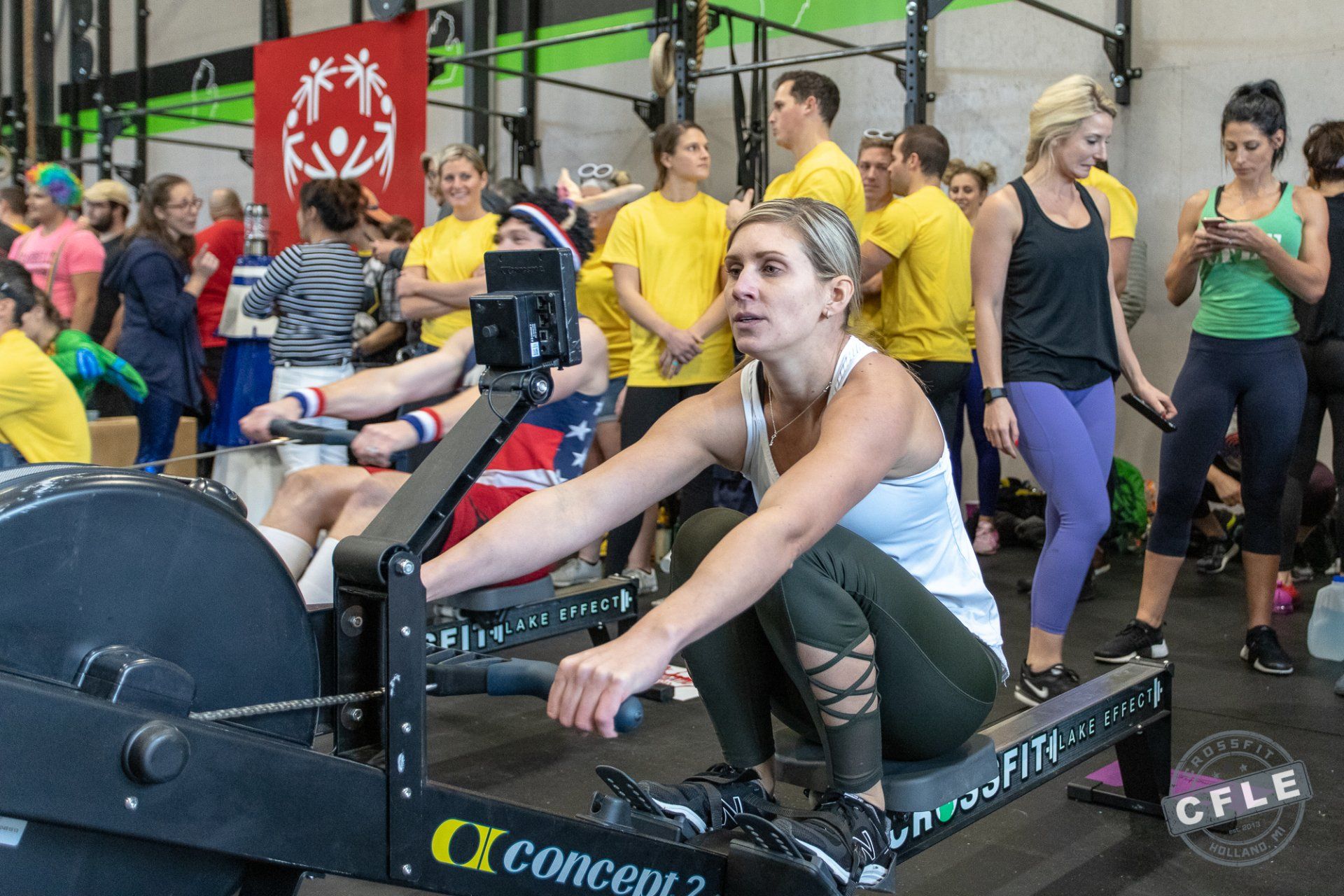 A woman is riding a rowing machine in a gym.