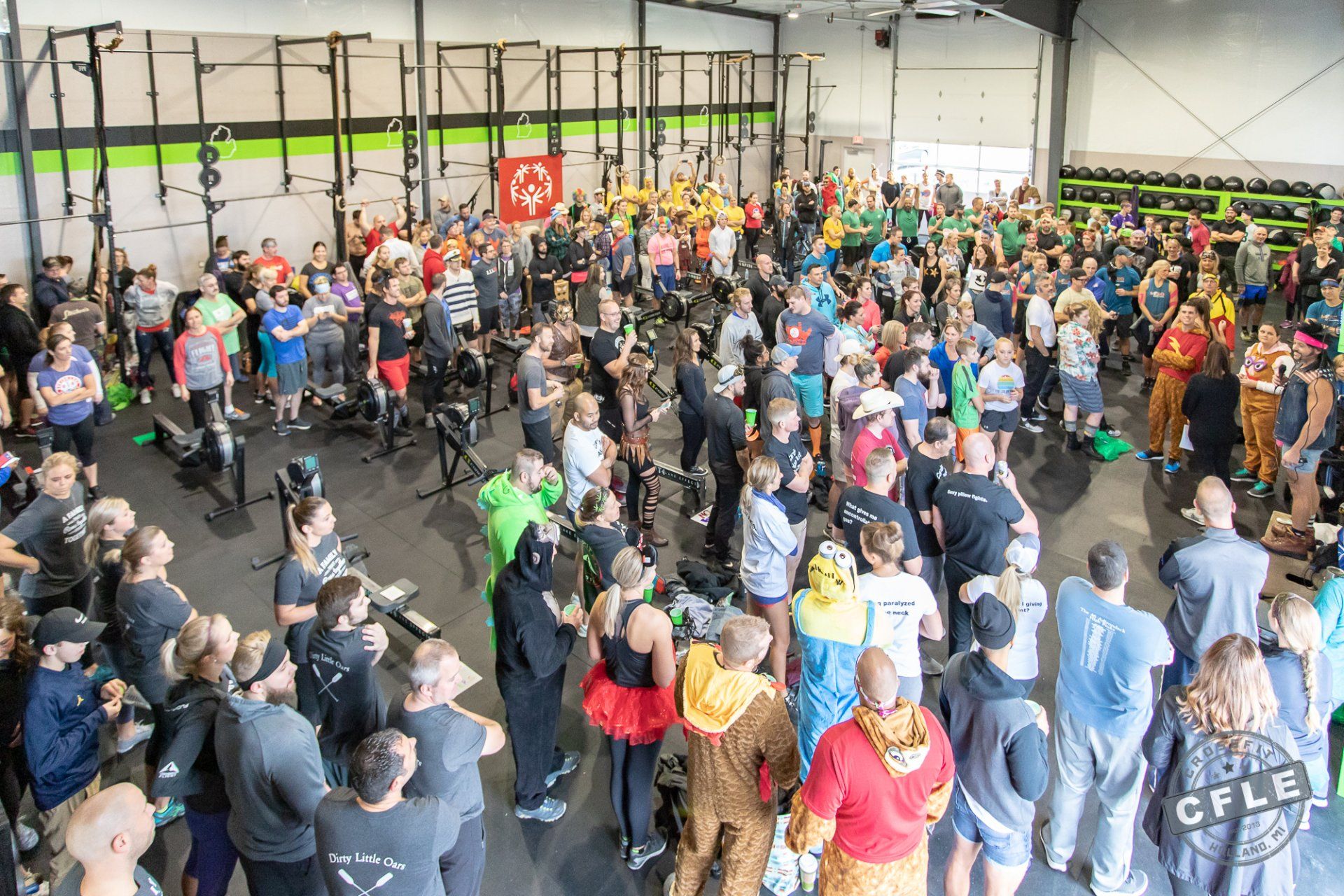 A large group of people are standing in a gym.
