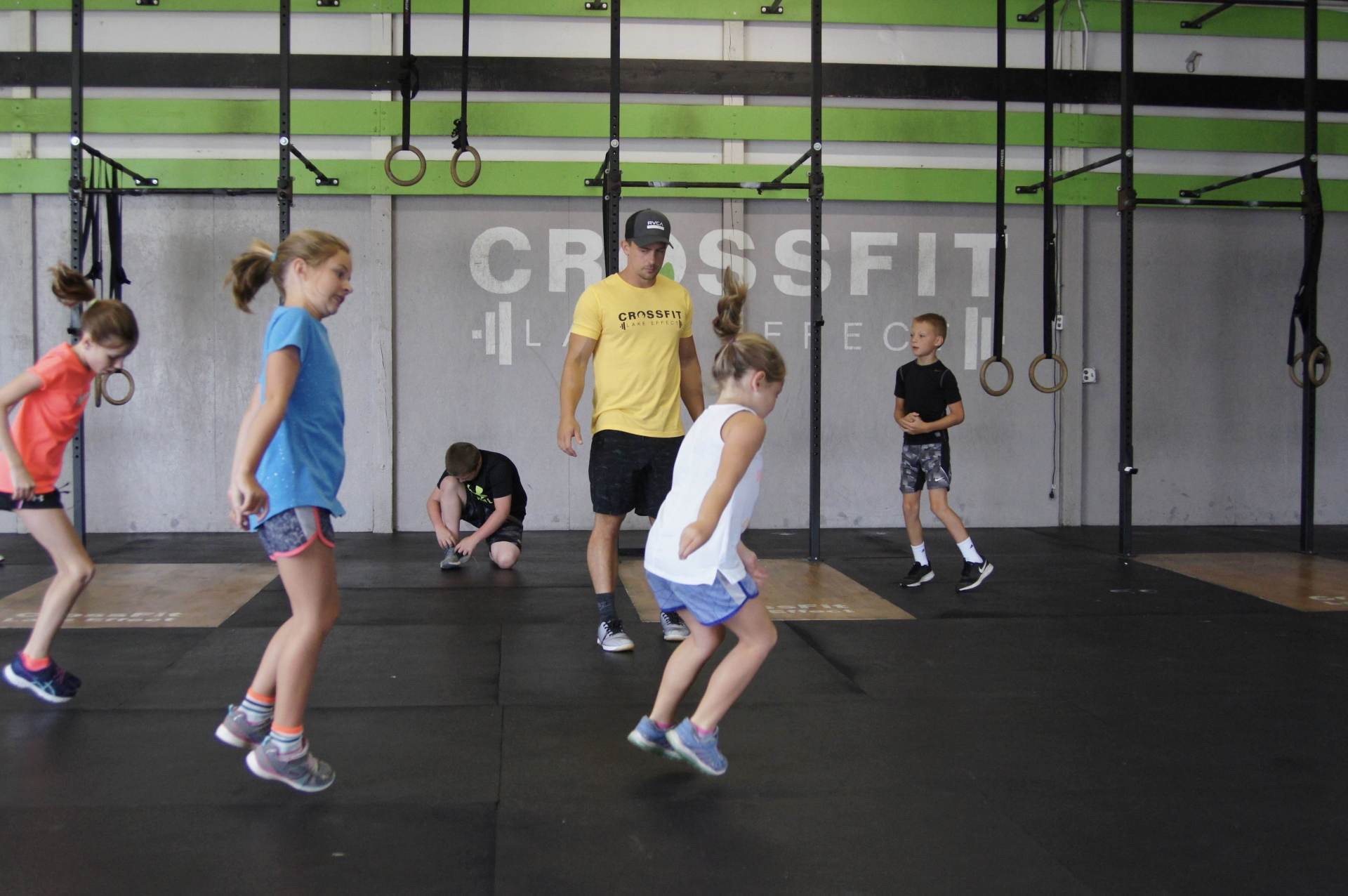 A group of children are doing exercises in a gym.