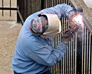 Men welding a metal fence - Fence Contractors & Builders