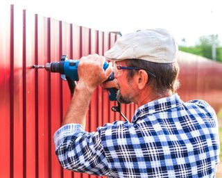 Men drilling a metal fence - Fence Contractors and Builders