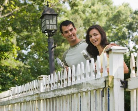 Smiling couple painting fence together - Estate Fence in Covington, WA