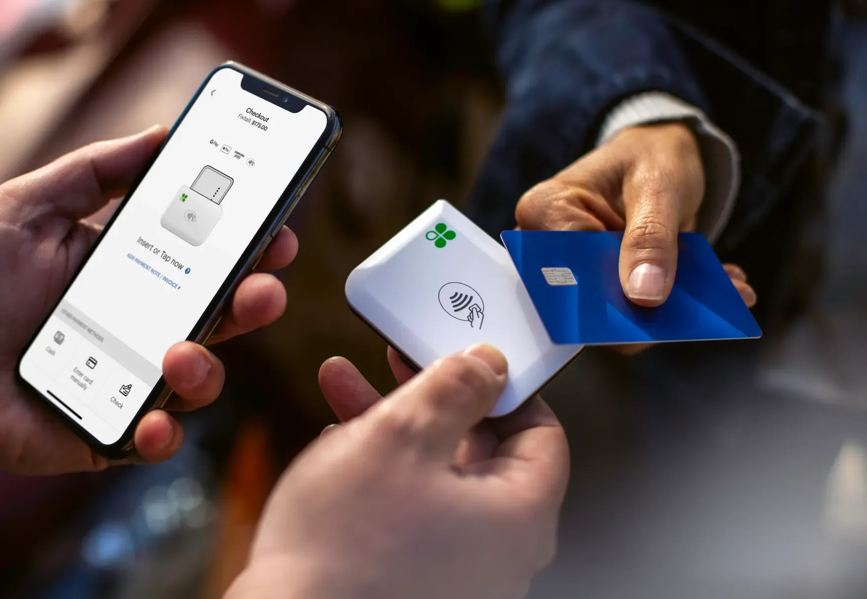 a person is holding a cell phone and a credit card to pay via a Clover Go .