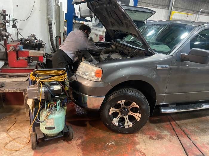 A man is working under the hood of a truck in a garage | Cetus Automotive Repair Centre