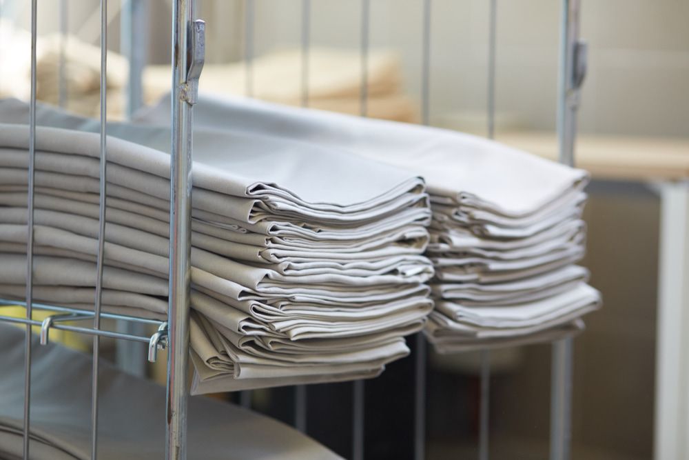 A Stack Of Towels Is Sitting On Top Of A Metal Rack — Macquarie Dry Cleaners In Dubbo, NSW