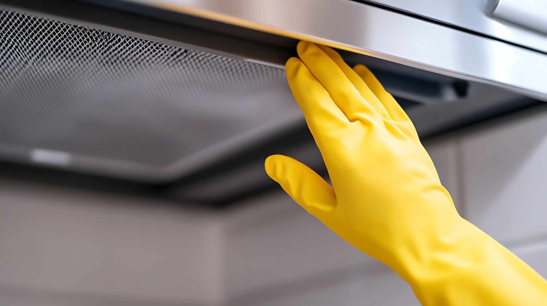 Yellow glove stretches up to change vent hood filter