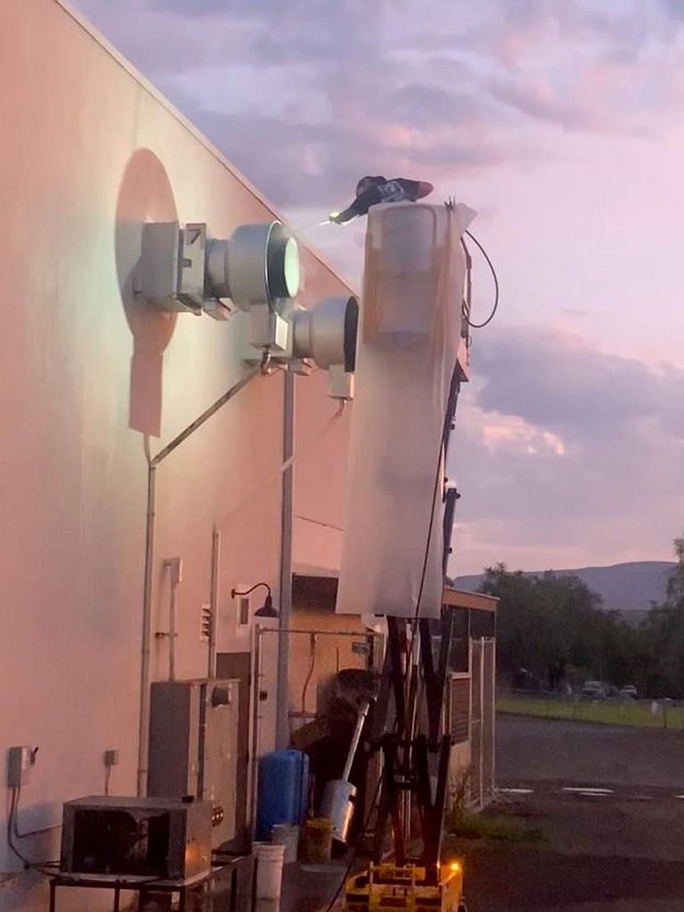 Worker Cleaning the Exhaust System of the Commercial Kitchen