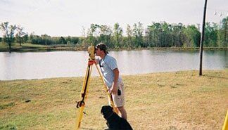 Topographic Surveys — Man Using Surveyor in Auburn, AL