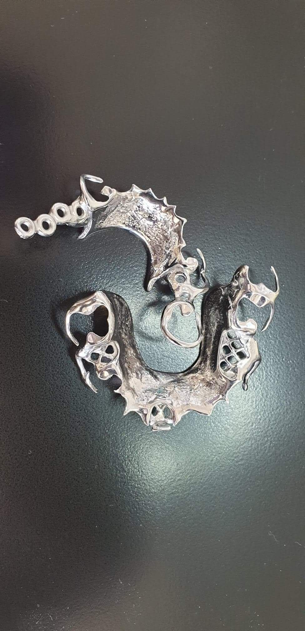 A Metal Teeth Retainer Placed on the Surface — Goonellabah Denture Clinic In Goonellabah, NSW