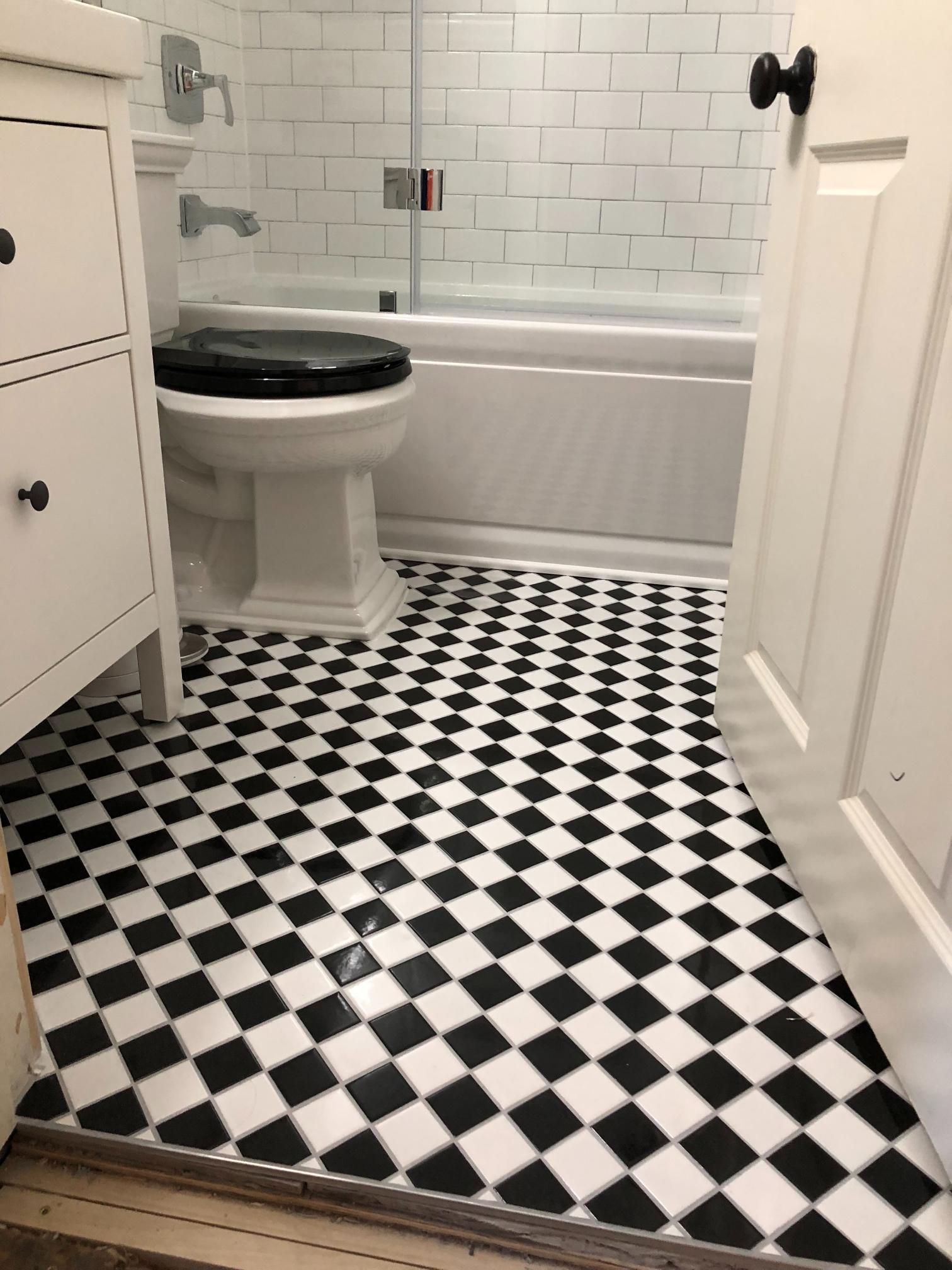 A bathroom with a black and white checkered floor