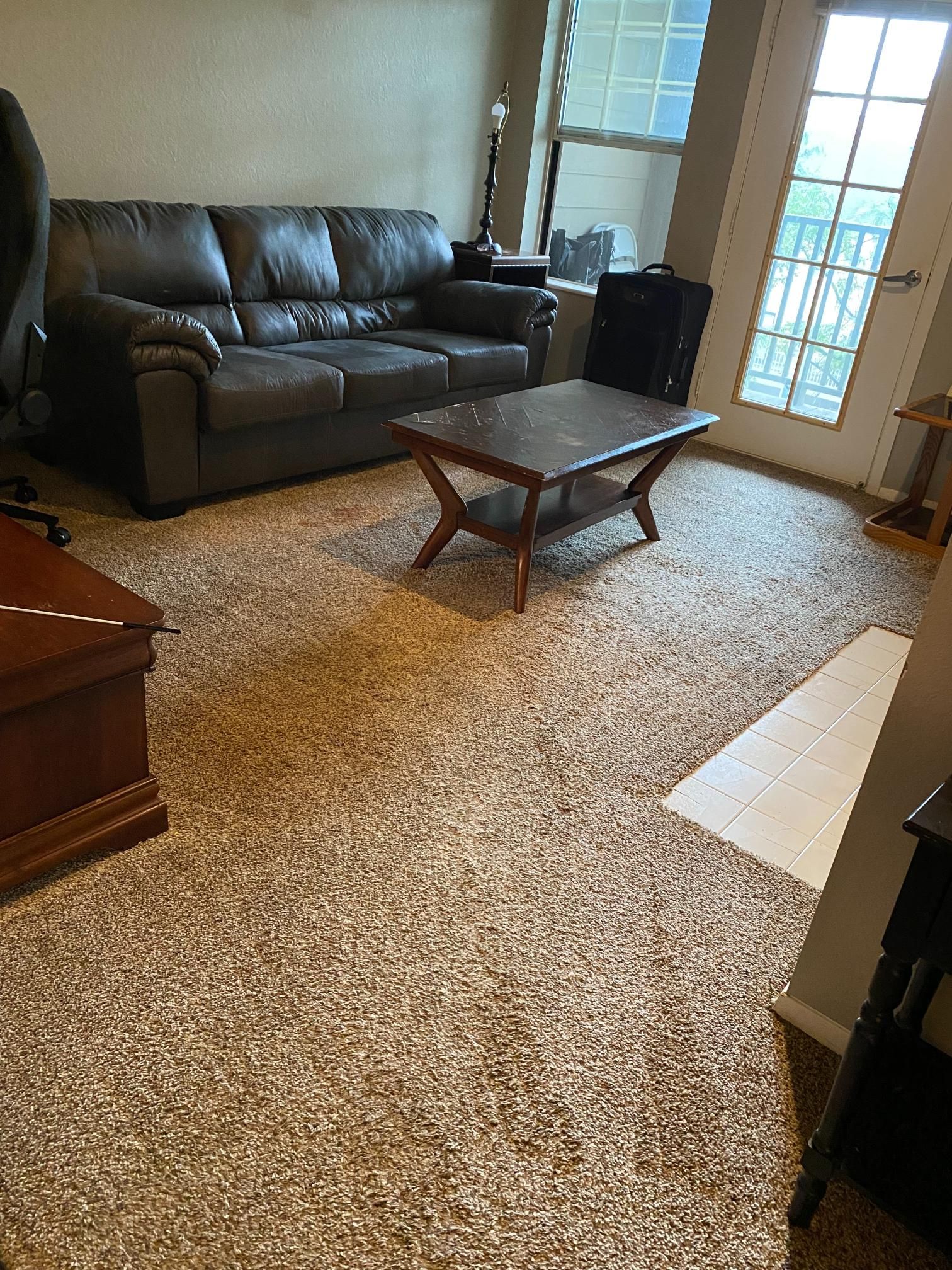 A living room with a couch , coffee table , and chair.