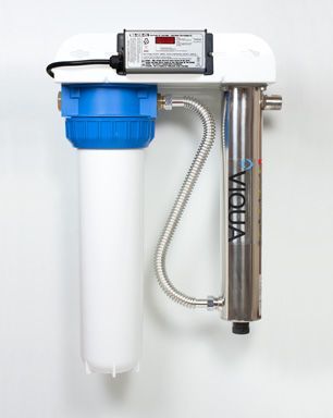 A water filter is hanging on a white wall.