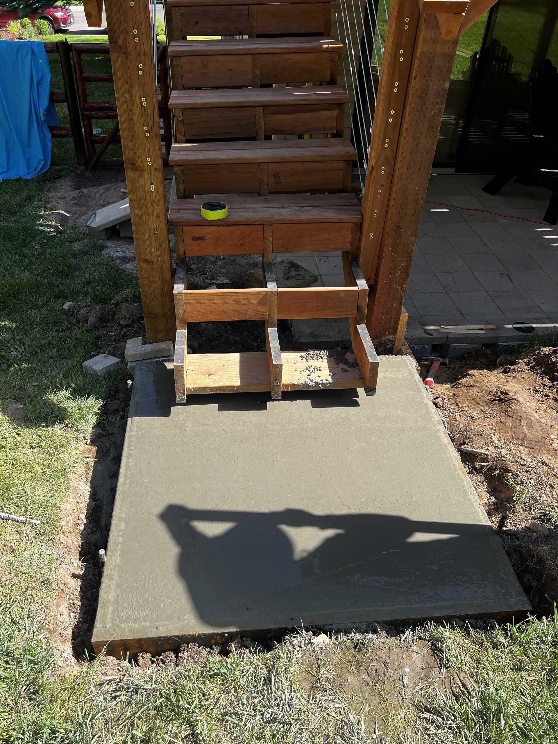 A wooden staircase is sitting on top of a concrete platform.