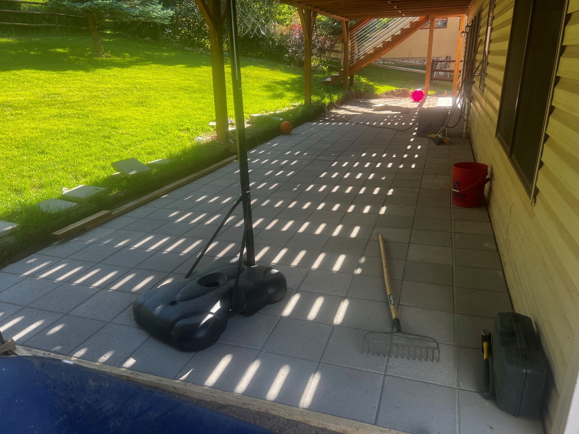 A patio with a basketball hoop and a bucket on it