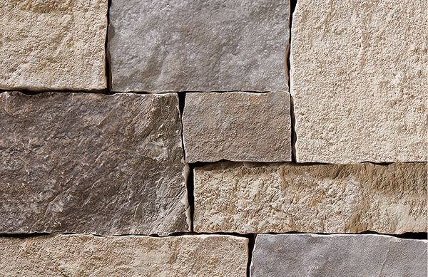 Close-up of a stone wall with light beige and gray rectangular blocks.