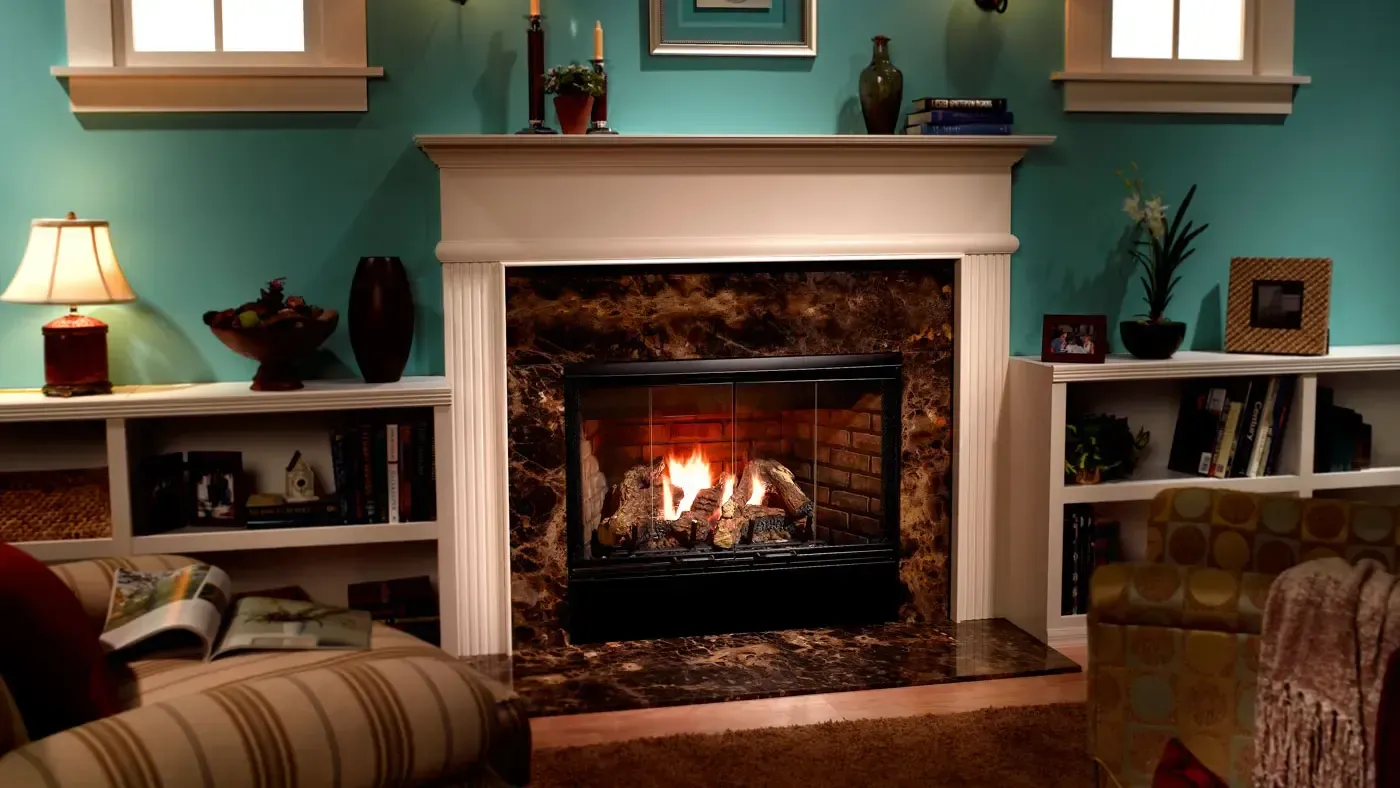 Fireplace in a room with teal walls, white shelves, and a cozy seating area.