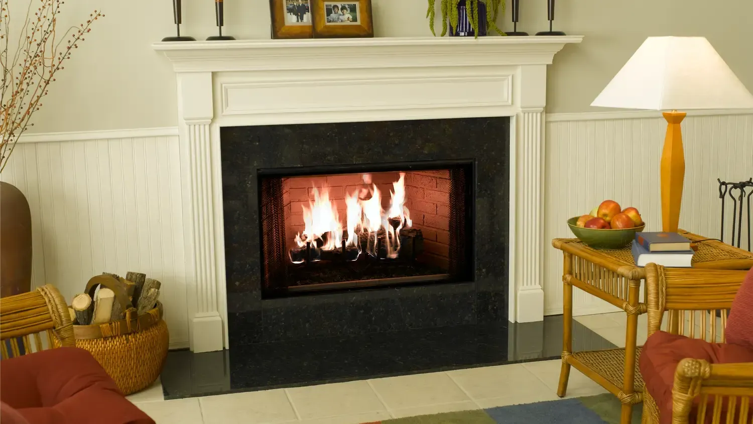Fireplace with burning logs, mantel with decor, and nearby seating.