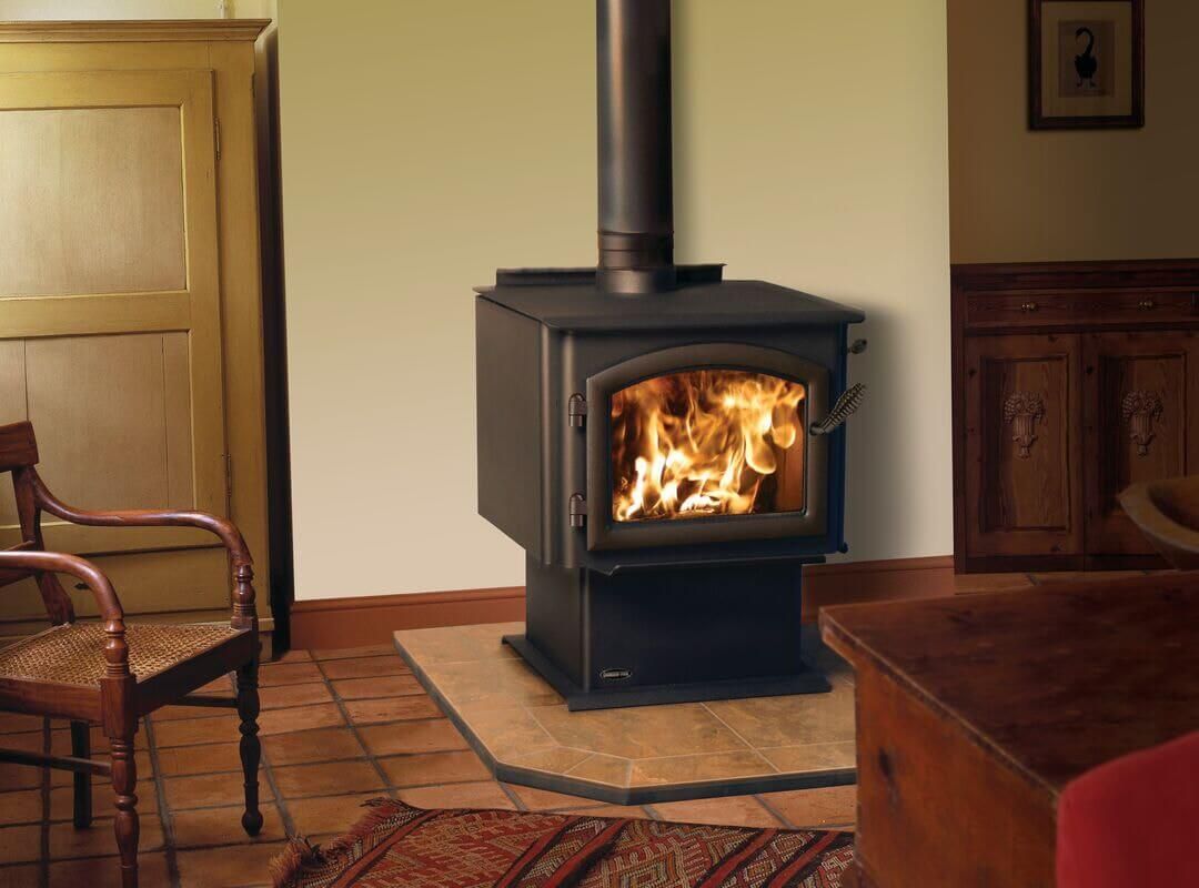 Wood-burning stove with flames, chimney, in a rustic living room setting.