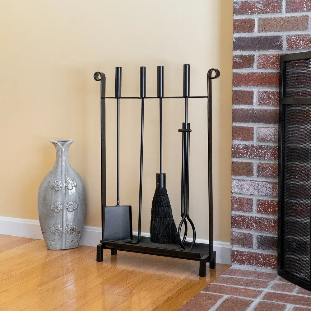 Black fireplace tool set with a vase next to a brick wall.