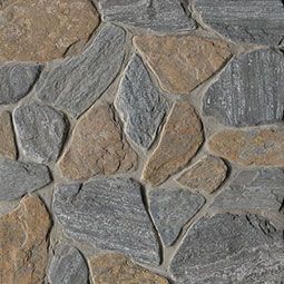 Close-up of a stone wall featuring irregularly shaped gray and tan stones with gray mortar.