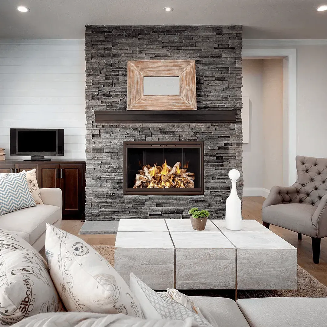 Living room with stone fireplace, sofa, and accent chair.