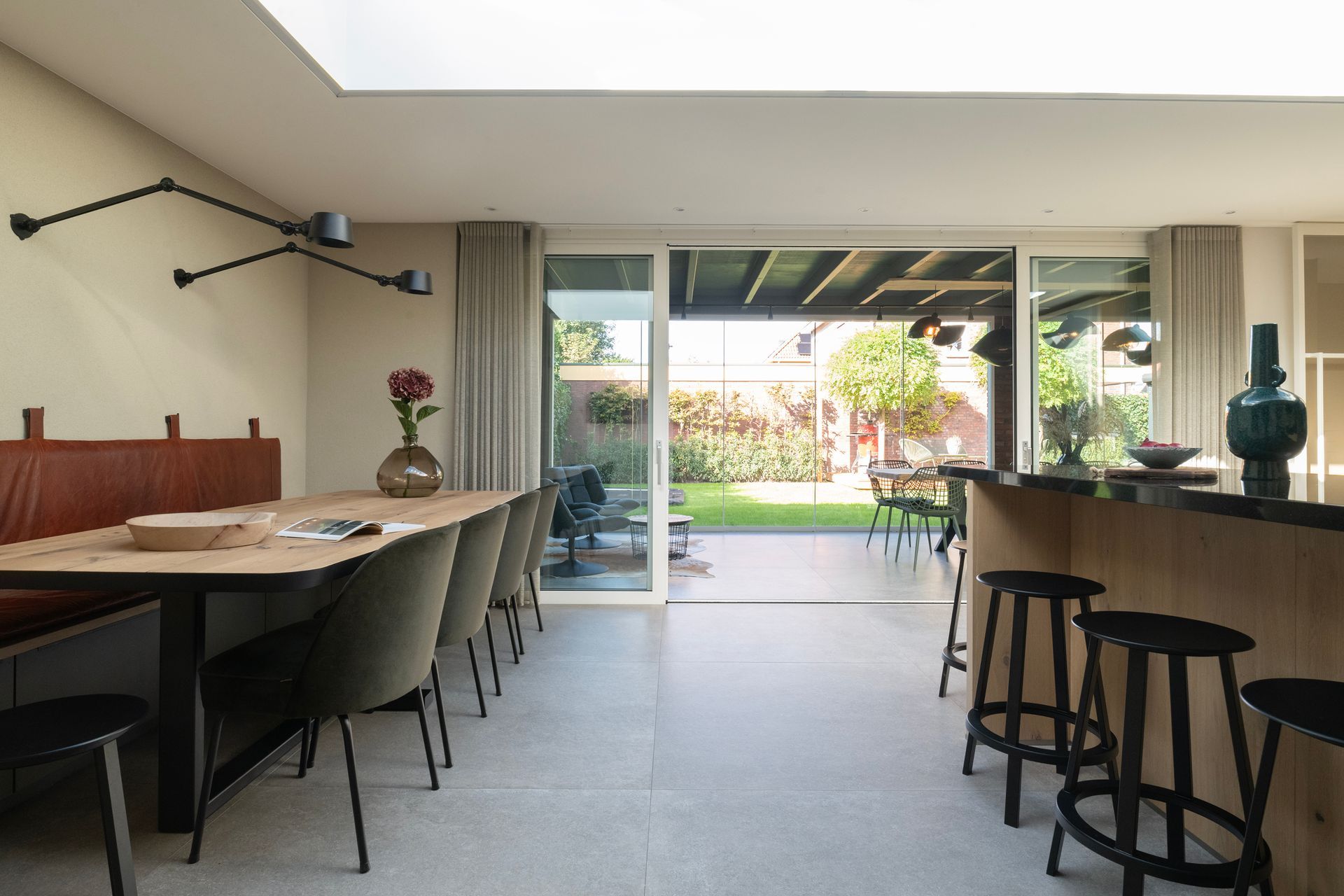 Binnen met buiten verbinden. Door de tuinkamer met een glazen schuifdeur wordt de leefkeuken verlengt naar de tuin toe.