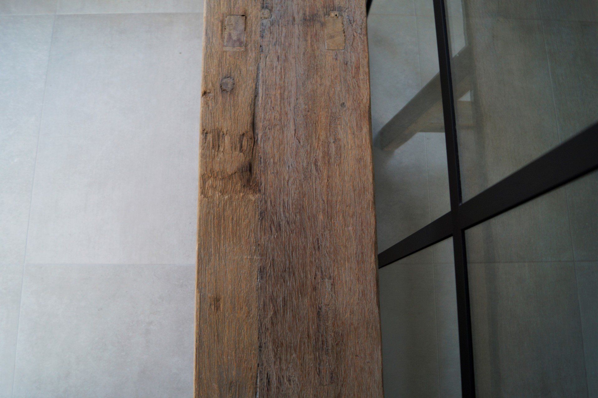 Betonlook badkamer met zwarte kranen.