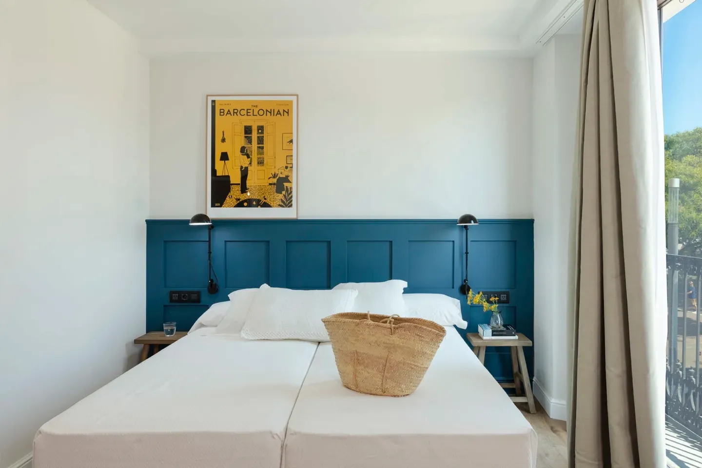 A bedroom with a blue headboard and a basket on the bed.