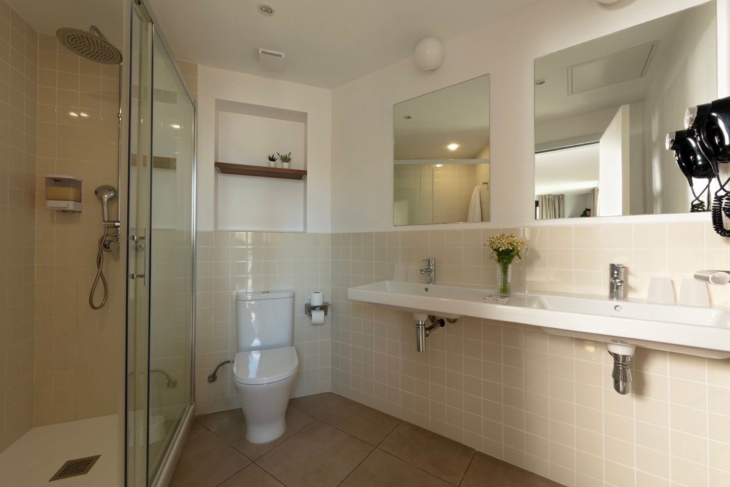 A bathroom with a toilet , sink and shower.