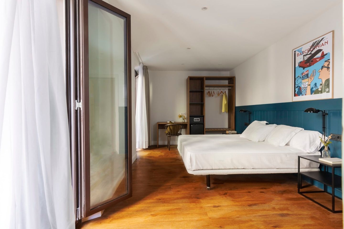 A hotel room with two beds and a large window.