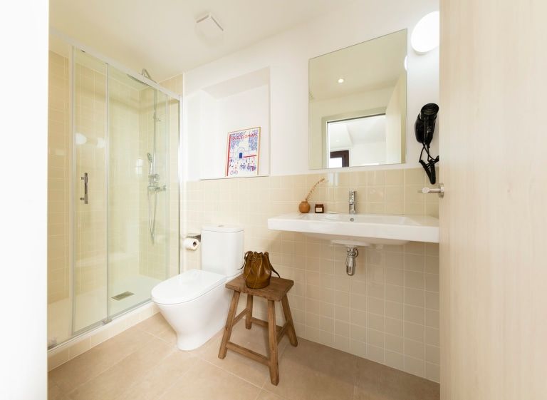 A bathroom with a toilet , sink , mirror and shower.