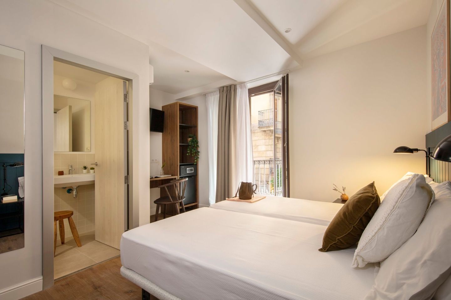 A hotel room with two beds , a sink and a balcony.