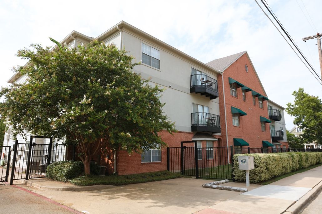 A large apartment building with a tree in front of it