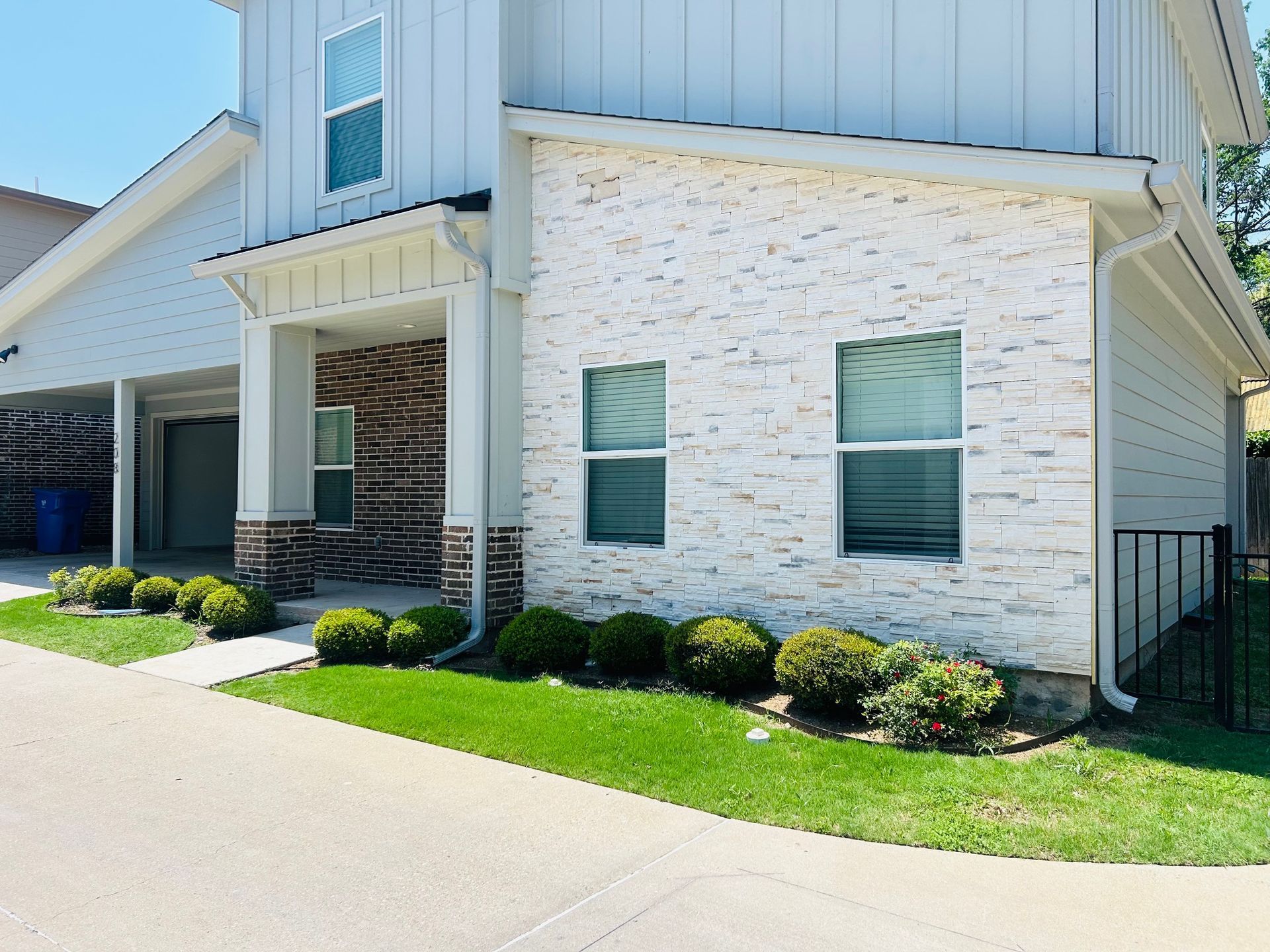 A white house with a brick facade and a lot of windows