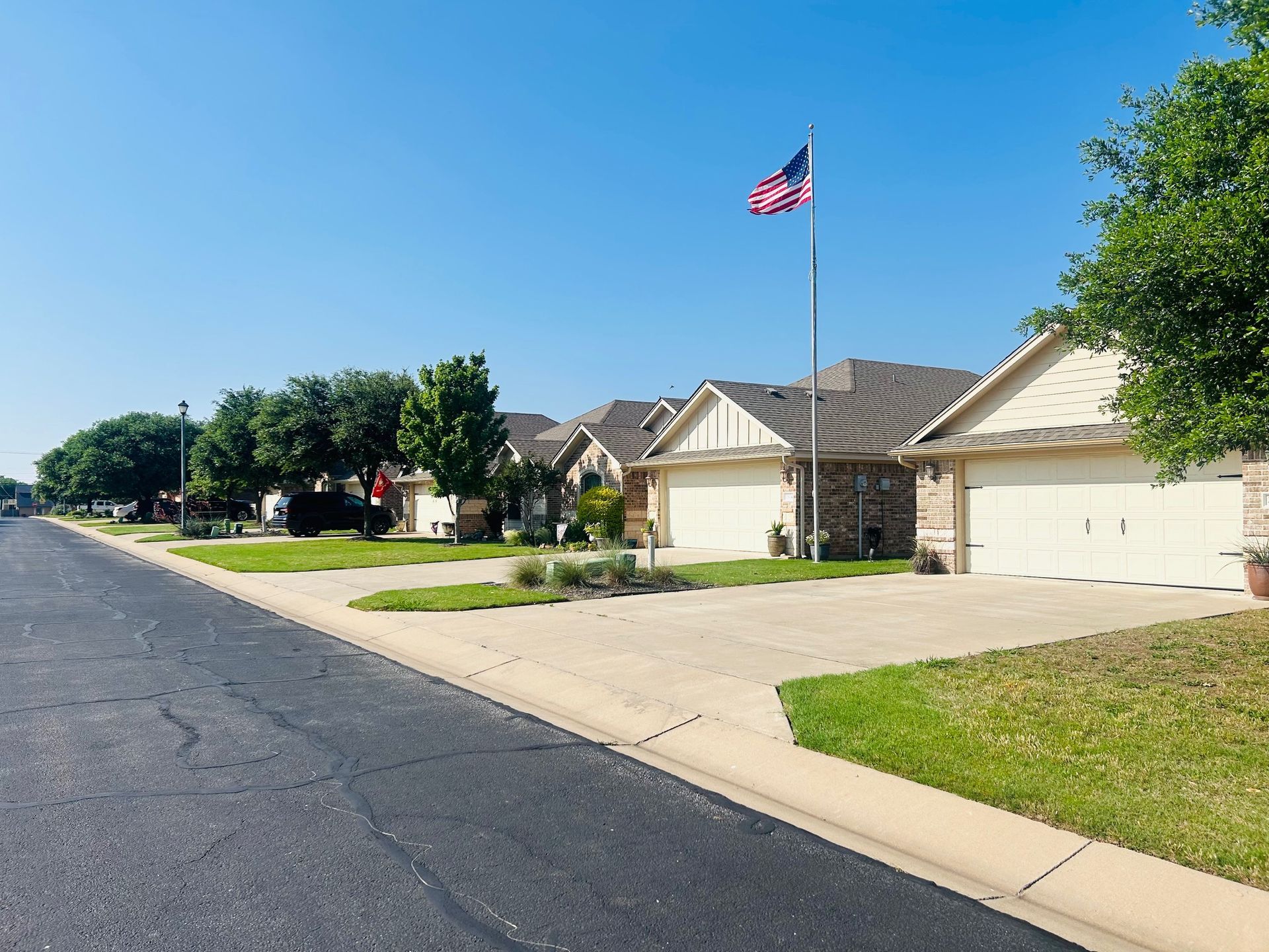 A row of houses with a flag on the side of the road