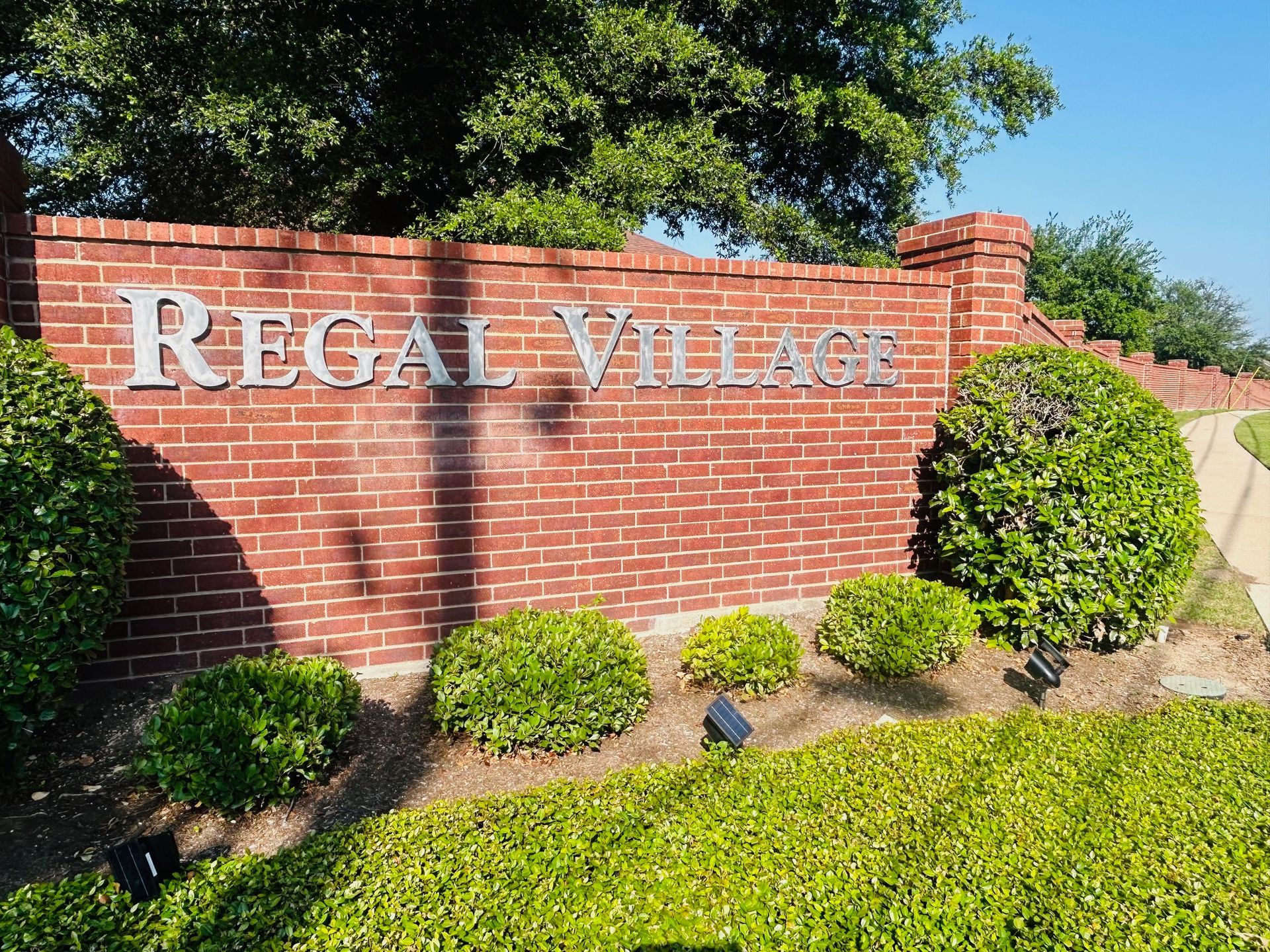 A brick wall with a sign that says regal village