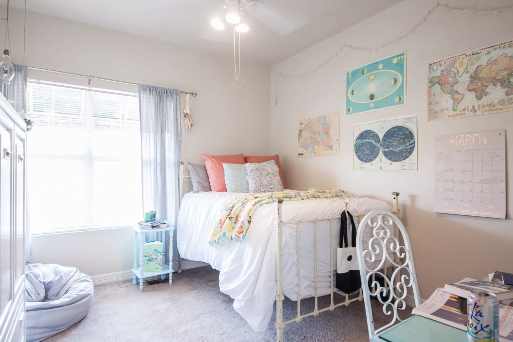 A bedroom with a bed , chair , nightstand , and window.
