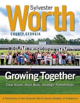 Front of our magazine. A baby in a plaid shirt sitting in a field of cotton